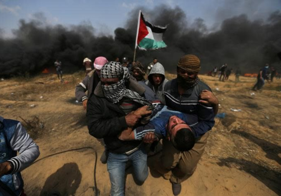 A wounded demonstrator is evacuated during clashes with Israeli troops at a protest at the Israel-Gaza border in the southern Gaza Strip, April 27, 2018 Photo By: IBRAHEEM ABU MUSTAFA / REUTERS IDF strikes six Hamas targets in Gaza Strip