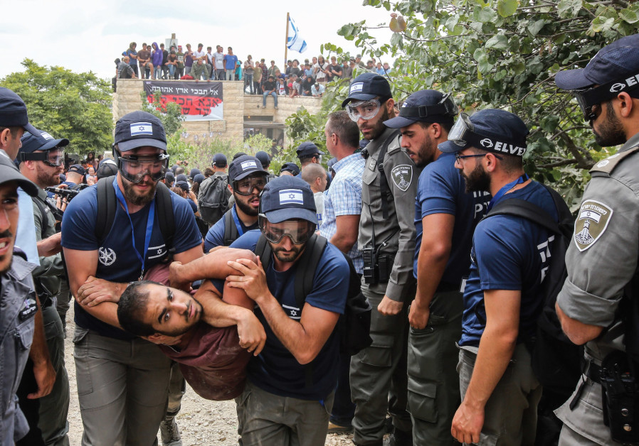 Security forces evict a demonstrator from Netiv Ha’avot on Tuesday Photo By: MARC ISRAEL SELLEM/THE JERUSALEM POST MKs hope West Bank outpost authorization bill will pass this month