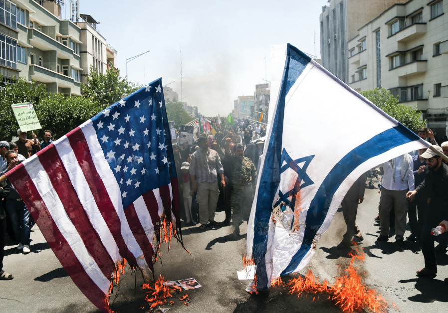 IRANIANS BURN US and Israeli flags during a protest in Tehran in June Photo By: TASNIM NEWS AGENCY/HANDOUT VIA REUTERS IRANIANS BURN US and Israeli flags during a protest in Tehran in June
