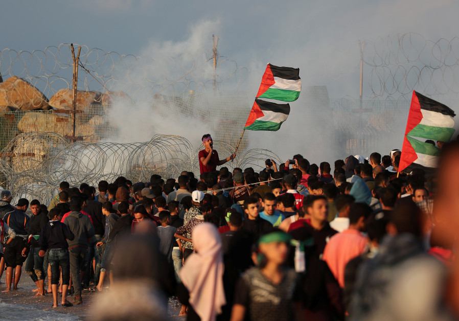 A demonstrator holding Palestinian flags shouts during a protest calling for lifting the Israeli blockade on Gaza, at the beachfront border with Israel, in the northern Gaza Strip November 5, 2018 Photo By: MOHAMMED SALEM/REUTERS Palestinians in Gaza attack Qatari envoy with stones after $15m. payment