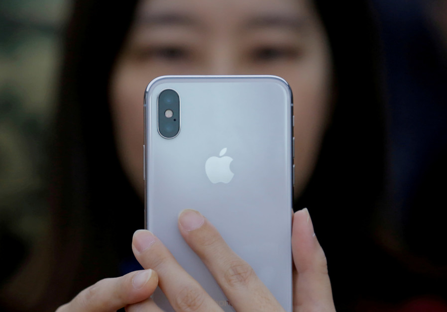 An attendee uses a new iPhone X during a presentation for the media in Beijing, China October 31, 2017. Photo By: REUTERS/THOMAS PETER An attendee uses a new iPhone X during a presentation for the media in Beijing, China, 2017.