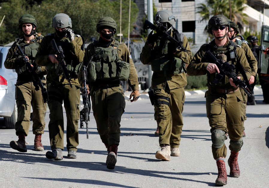 Israeli soldiers walk during clashes with Palestinians in Ramallah in the West Bank, 2018. Photo By: REUTERS/MOHAMAD TOROKMAN Israeli soldiers walk during clashes with Palestinians in Ramallah in the West Bank, 2018.