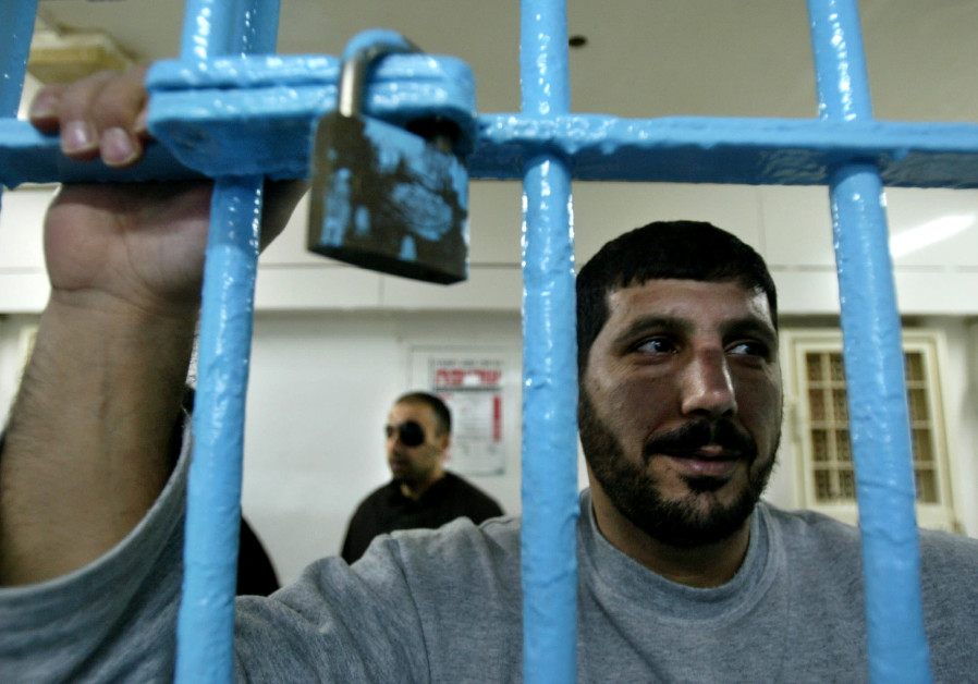 A Palestinian prisoner, convicted of security offences against Israel, looks out of his cell at Nitzan jail Photo By: REUTERS/NIR ELIAS Palestinian Authority paid NIS 502m to terrorist prisoners - report