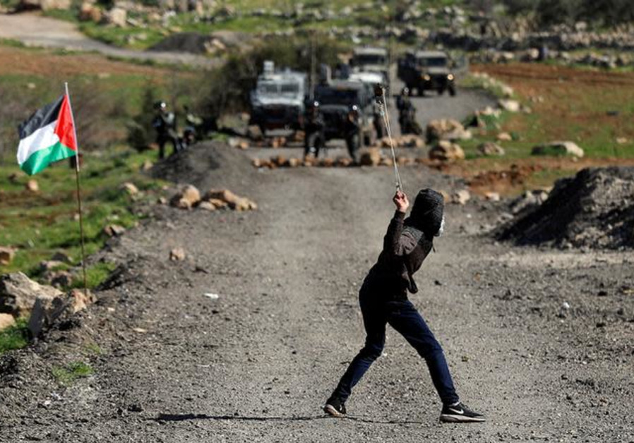 A Palestinian demonstrator uses a sling to hurl stones at Israeli troops during clashes at a protest in al-Mughayyir village near Ramallah Photo By: REUTERS/MOHAMAD TOROKMAN A Palestinian demonstrator uses a sling to hurl stones at Israeli troops during clashes at a protest