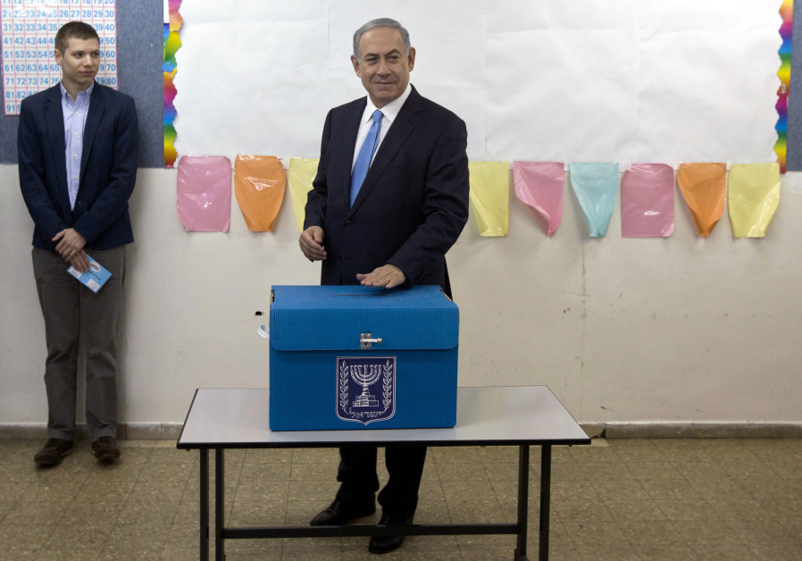 Israel's Prime Minister Benjamin Netanyahu casts his ballot for the parliamentary election as his son Yair stands behind him at a polling station in Jerusalem March 17, 2015. Photo By: SEBASTIAN SCHEINER/POOL VIA REUTERS Hamas won't say it, but they prefer Netanyahu - Analysis