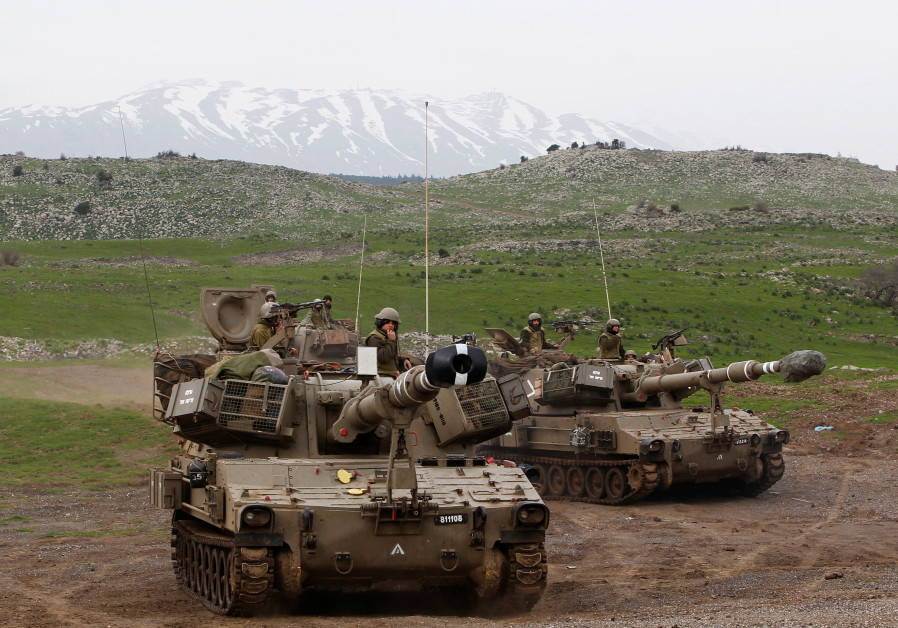 Mount Hermon is seen in the background as Israeli soldiers travel on mobile artillery units after an exercise in the Golan Heights, February 2013 Photo By: BAZ RATNER/REUTERS Mount Hermon is seen in the background as Israeli soldiers travel on mobile artillery units after an