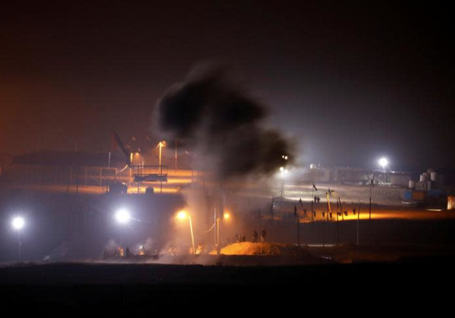 Smoke rises after an explosion as Palestinians take part in a night protest held along the Gaza side of the border with Israel Photo By: REUTERS/AMIR COHEN Smoke rises after an explosion as Palestinians take part in a night protest held along the Gaza side