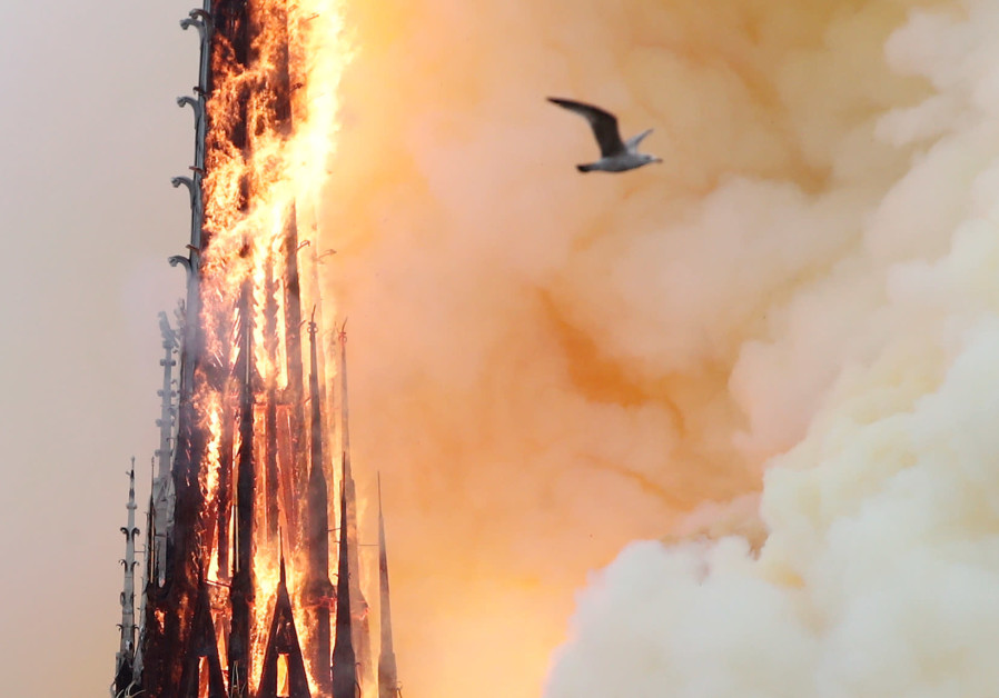 Smoke billows as fire engulfs the spire of Notre Dame Cathedral in Paris, France April 15, 2019. Photo By: BENOIT TESSIER /REUTERS Smoke billows as fire engulfs the spire of Notre Dame Cathedral in Paris, France April 15, 2019.
