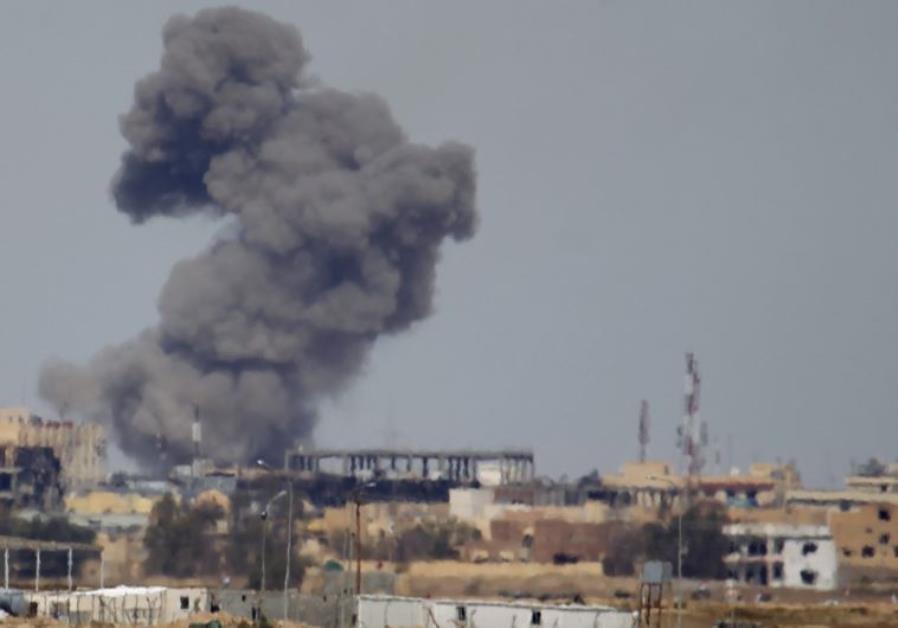 A plume of smoke rises above a building during an air strike against Islamic State fighters in Tikrit, Iraq March 27, 2015. Photo By: REUTERS isis airstrike