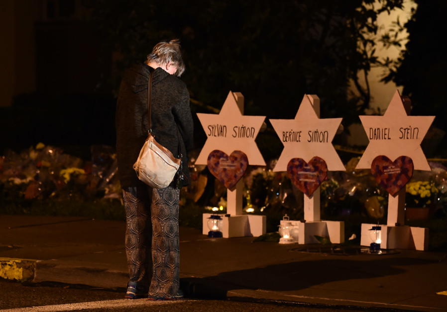 A woman bows her head in front of a memorial on October 28, 2018, at the Tree of Life synagogue after a shooting there left 11 people dead in the Squirrel Hill neighborhood of Pittsburgh on October 27 Photo By: BRENDAN SMIALOWSKI / AFP A woman bows her head in front of a memorial on October 28, 2018, at the Tree of Life synagogue