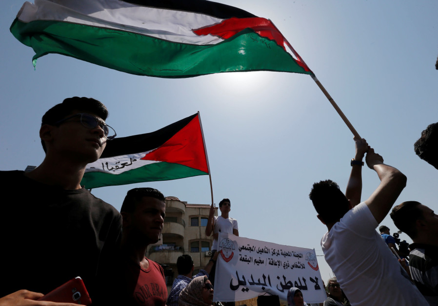 Palestinian refugees hold Palestinian flags and chant slogans during a protest in front of UNRWA office in Amman, September 2, 2018. Photo By: MUHAMMAD HAMED / REUTERS Palestinian refugees hold Palestinian flags and chant slogans during a protest in front of UNRWA off