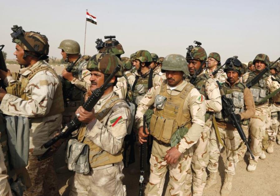 IRAQI SECURITY forces wait for vehicles traveling to Mosul to fight against Islamic State at an Iraqi army base in Camp Taji in Baghdad on February 21. Photo By: REUTERS IRAQI SECURITY forces wait for vehicles traveling to Mosul to fight against Islamic State at an Iraq
