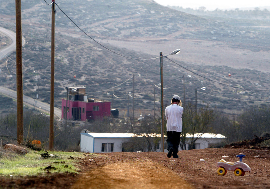 A Jewish settler walks at the Jewish settlement outpost of Adei Ad B in the West Bank Photo By: REUTERS/NIR ELIAS A Jewish settler walks at the Jewish settlement outpost of Adei Ad B in the West Bank