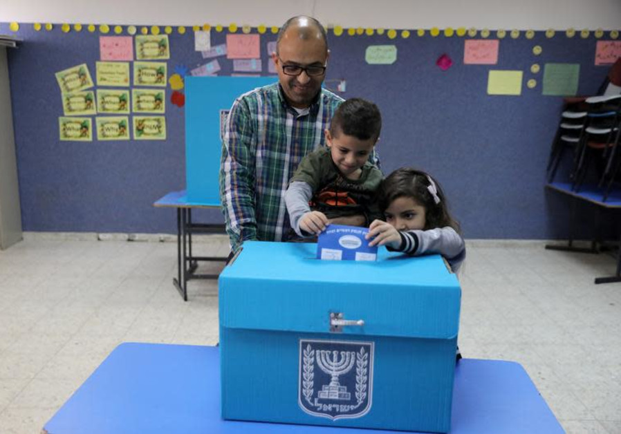 An Israeli-Arab father casts a ballot together with his children, as Israelis vote in a parliamentary election, at a polling station in Umm al-Fahm, Israel April 9, 2019 Photo By: AMMAR AWAD / REUTERS Israeli Arab voting