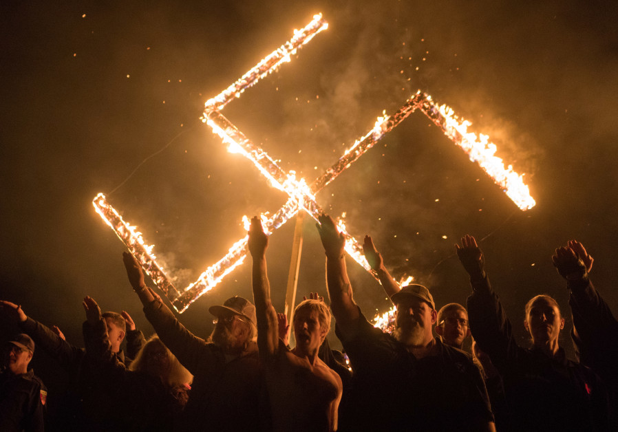 Supporters of the National Socialist Movement, a white nationalist political group, give Nazi salutes while taking part in a swastika burning at an undisclosed location in Georgia, US on April 21, 2018 Photo By: GO NAKAMURA/REUTERS American Jews are asking: Is it safe to pray in synagogue?