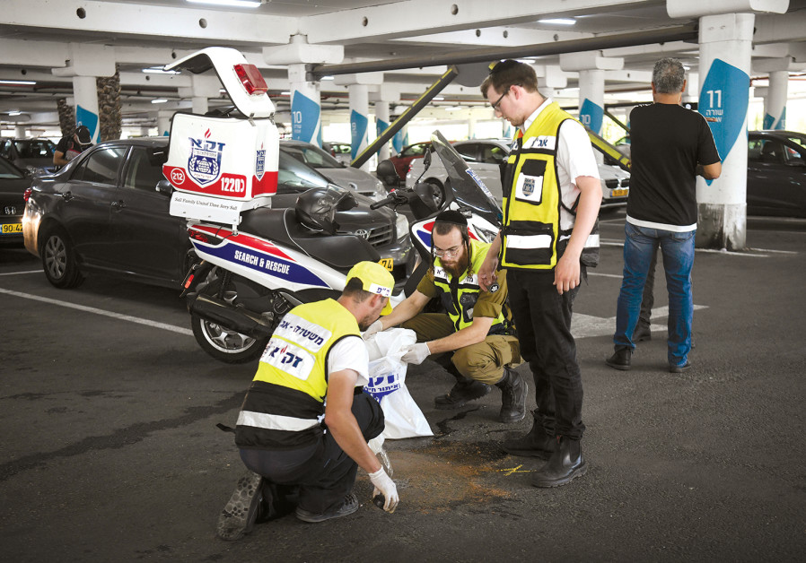 ZAKA MEDICAL personnel attend the scene where Ofir Hisdai was shot dead during an argument over a parking spot at the Azrieli Mall in Ramle on Sunday Photo By: FLASH90 ZAKA MEDICAL personnel attend the scene where Ofir Hisdai was shot dead during an argument over a pa