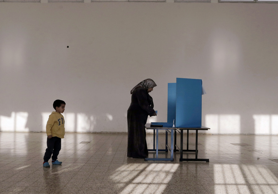 An Israeli Arab stands behind a voting booth before casting her ballot at a polling station in the northern town of Umm el-Fahm March 17, 2015. Millions of Israelis turned out to vote on Tuesday in a tightly-fought election, with Prime Minister Benjamin Netanyahu facing an uphill battle to defeat a Photo By: AMMAR AWAD / REUTERS For Arab voters, it's 'Anyone but Bibi'
