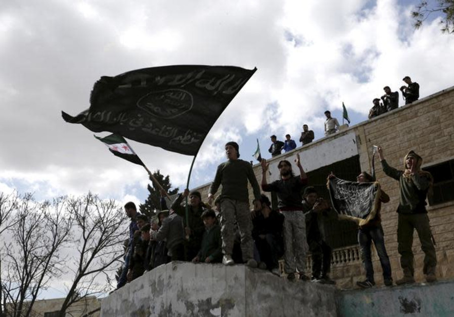 Protesters carry Al-Qaeda flags during an anti-government protest after Friday prayers in the town of Marat Numan in Idlib province, Syria Photo By: KHALIL ASHAWI / REUTERS Protesters carry Al-Qaeda flags during an anti-government protest after Friday prayers