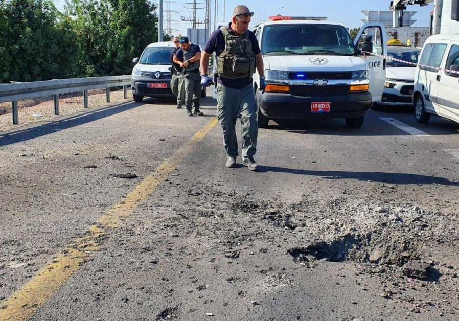 Police sappers inspect site of a rocket that landed on Road 4 in Israel Photo By: POLICE SPOKESPERSON'S UNIT Police sappers inspect site of a rocket that landed on Road 4 in Israel