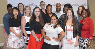 Thirteen community members—including military spouses, a veteran, and a National Guardsman—pose before being recognized June 30, 2017, in a graduation ceremony honoring the completion of a 10-week COMCAST customer service virtual class that secured their employment at the Hilton Garden Inn located a few miles from Fort Lee, Virginia. Photo by Amy Perry, courtesy of the U.S. Army.
