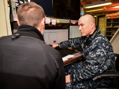 Chief Aviation Electronics Technician Michael Tagg, the command financial specialist aboard the aircraft carrier USS Nimitz, discusses finances with a sailor in 2018. Photo by Mass Communication Spc. Seaman Greg Hall, courtesy of the U.S. Navy.