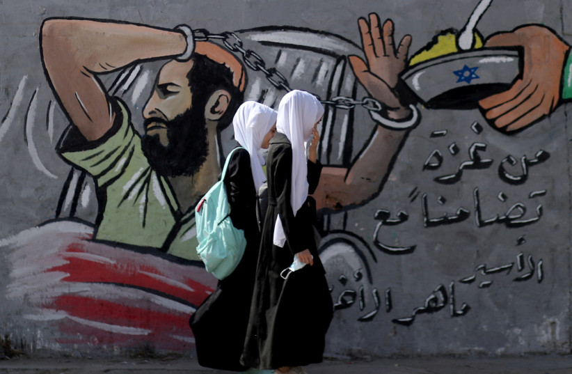 Palestinian students walk past a mural depicting hunger-striking Palestinian prisoner Maher Al-Akhras, Gaza Strip, October 19, 2020. (credit: REUTERS/MOHAMMED SALEM/FILE PHOTO) Palestinian students walk past a mural depicting hunger-striking Palestinian prisoner Maher Al-Akhras, Gaza Strip, October 19, 2020. (credit: REUTERS/MOHAMMED SALEM/FILE PHOTO)