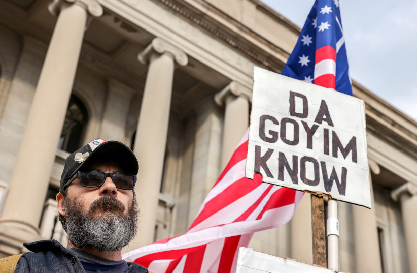 A protestor carries a white supremacist and antisemitic sign outside the Kenosha County Courthouse on the second day of jury deliberations in the Kyle Rittenhouse trial, in Kenosha, Wisconsin, US, November 17, 2021. (credit: REUTERS/EVELYN HOCKSTEIN) A protestor carries a white supremacist and antisemitic sign outside the Kenosha County Courthouse on the second day of jury deliberations in the Kyle Rittenhouse trial, in Kenosha, Wisconsin, US, November 17, 2021. (credit: REUTERS/EVELYN HOCKSTEIN)