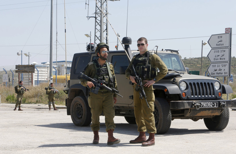 Israeli soldiers stand guard near the scene of an attack at Tapuach junction near the West Bank city of Nablus April 30, 2013 (credit: REUTERS) Israeli soldiers stand guard near the scene of an attack at Tapuach junction near the West Bank city of Nablus April 30, 2013 (credit: REUTERS)