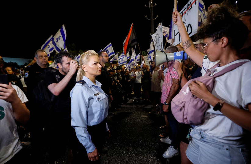 A policewoman stands opposite to a protester during a demonstration, following a parliament vote on a contested bill that limits Supreme Court powers to void some government decisions, near the Knesset, Israel's parliament in Jerusalem July 24, 2023 (credit: AMIR COHEN/REUTERS) A policewoman stands opposite to a protester during a demonstration, following a parliament vote on a contested bill that limits Supreme Court powers to void some government decisions, near the Knesset, Israel's parliament in Jerusalem July 24, 2023 (credit: AMIR COHEN/REUTERS)