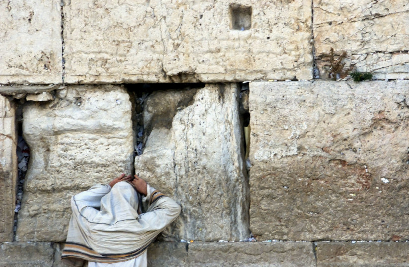 An ultra-Orthodox jew prays at the Westen Wall July 17, 2002 on Tisha B'Av (credit: LASZLO BALOGH/REUTERS) An ultra-Orthodox jew prays at the Westen Wall July 17, 2002 on Tisha B'Av (credit: LASZLO BALOGH/REUTERS)