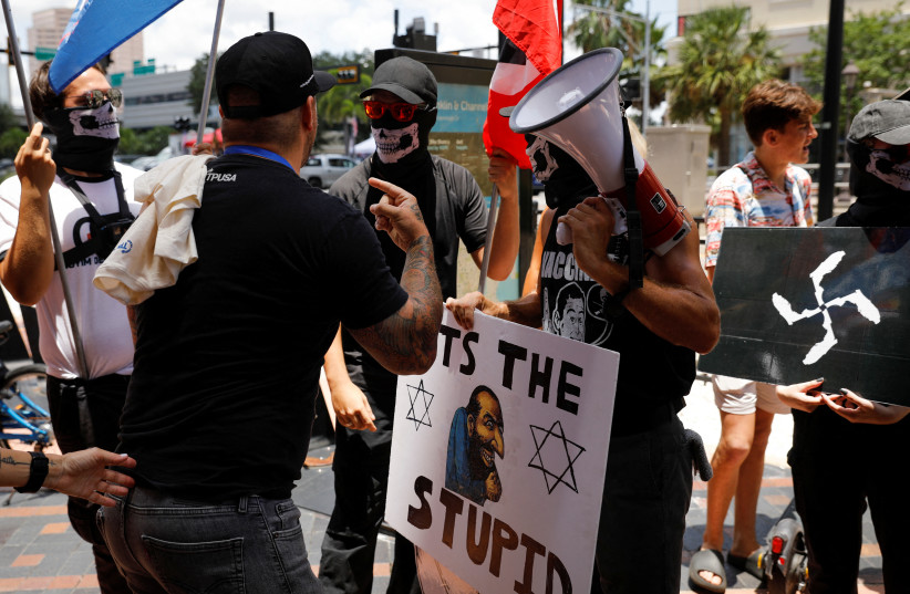 People wearing antisemitism and nazi symbols argue with conservatives during a protest outside the Tampa Convention Center where the Turning Point USA’s (TPUSA) Student Action Summit (SAS) is held, in Tampa, Florida, U.S. July 23, 2022. (credit: REUTERS/MARCO BELLO) People wearing antisemitism and nazi symbols argue with conservatives during a protest outside the Tampa Convention Center where the Turning Point USA’s (TPUSA) Student Action Summit (SAS) is held, in Tampa, Florida, U.S. July 23, 2022. (credit: REUTERS/MARCO BELLO)