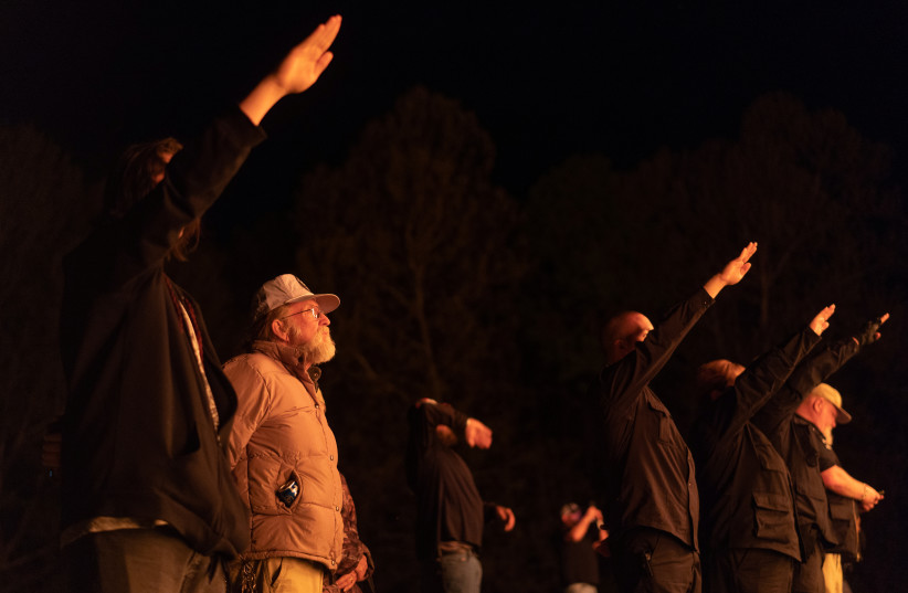 Supporters of the National Socialist Movement, a white nationalist political group, give Nazi salutes while taking part in a swastika burning at an undisclosed location in Georgia, U.S. on April 21, 2018. (credit: REUTERS) Supporters of the National Socialist Movement, a white nationalist political group, give Nazi salutes while taking part in a swastika burning at an undisclosed location in Georgia, U.S. on April 21, 2018. (credit: REUTERS)