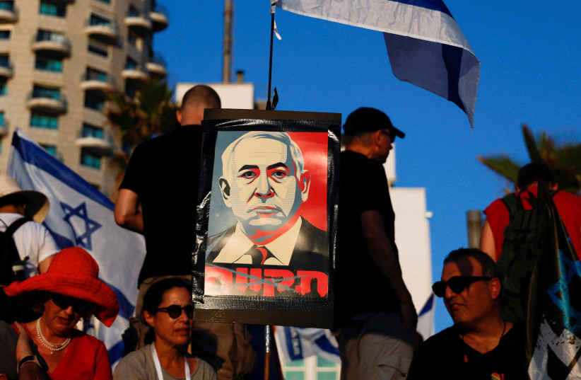 A placard depicting Israeli Prime Minister Benjamin Netanyahu is seen as people demonstrate on the 'Day of National Resistance' in protest against him and his nationalist coalition government's judicial overhaul, near U.S. Consulate in Tel Aviv, Israel July 18, 2023 (credit: REUTERS/AMMAR AWAD) A placard depicting Israeli Prime Minister Benjamin Netanyahu is seen as people demonstrate on the 'Day of National Resistance' in protest against him and his nationalist coalition government's judicial overhaul, near U.S. Consulate in Tel Aviv, Israel July 18, 2023 (credit: REUTERS/AMMAR AWAD)