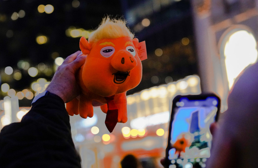 Guy Jacobson, of New York, photographs a plush toy depicting former U.S. President Donald Trump as an orange pig outside Trump Tower after Trump's indictment by a Manhattan grand jury following a probe into hush money paid to porn star Stormy Daniels, in New York City, U.S., April 3, 2023 (credit: BING GUAN/REUTERS) Guy Jacobson, of New York, photographs a plush toy depicting former U.S. President Donald Trump as an orange pig outside Trump Tower after Trump's indictment by a Manhattan grand jury following a probe into hush money paid to porn star Stormy Daniels, in New York City, U.S., April 3, 2023 (credit: BING GUAN/REUTERS)