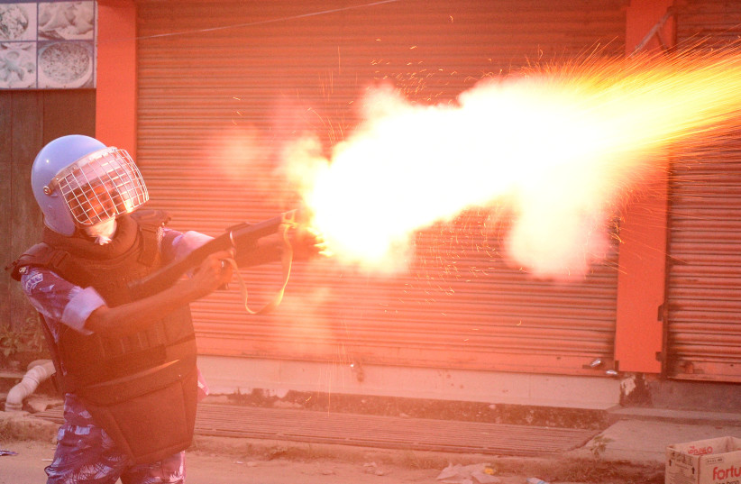 A riot police officer fires a tear smoke shell to disperse demonstrators protesting against the killing of two Meitei students in Imphal, Manipur, India, September 27, 2023. (credit: REUTERS/STRINGER) A riot police officer fires a tear smoke shell to disperse demonstrators protesting against the killing of two Meitei students in Imphal, Manipur, India, September 27, 2023. (credit: REUTERS/STRINGER)