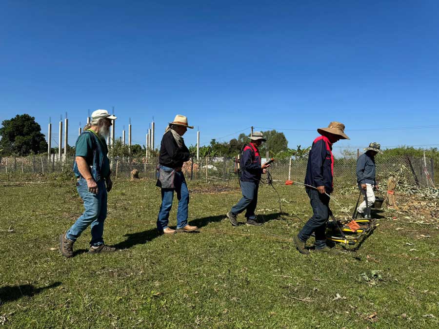 Don Super, second from left, and fellow veteran John Jones, far left, tag along with workers from the U.S.-based Aqua Survey, detecting mines at the site of a school construction project in Laos. (Photo courtesy of documentary film Collateral Damage)